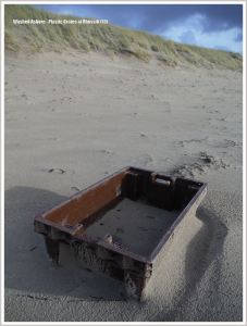 Brown plastic flotsam crate on a sandy beach
