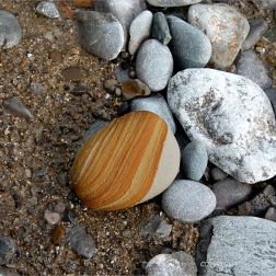 Pebbles on the water's edge at Pwll Du Bay