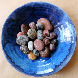 Colourful pebbles in a blue bowl
