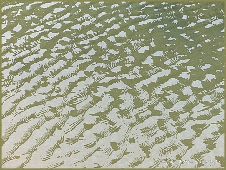 Close-up photograph of reflected light on rippled water