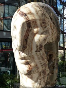 Carved stone head by Emily Young displayed at Neo Bankside in London