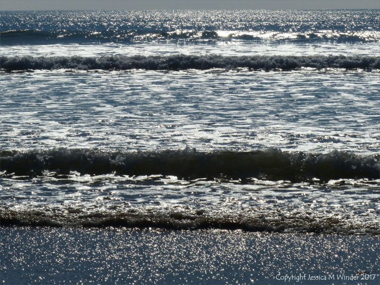 Waves and surf on the incoming tide sparkling in the sunshine