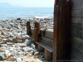 Remnants of an old wood and iron breakwater on the seashore
