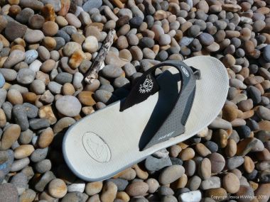 Flip-flop sandal washed up on a pebble beach