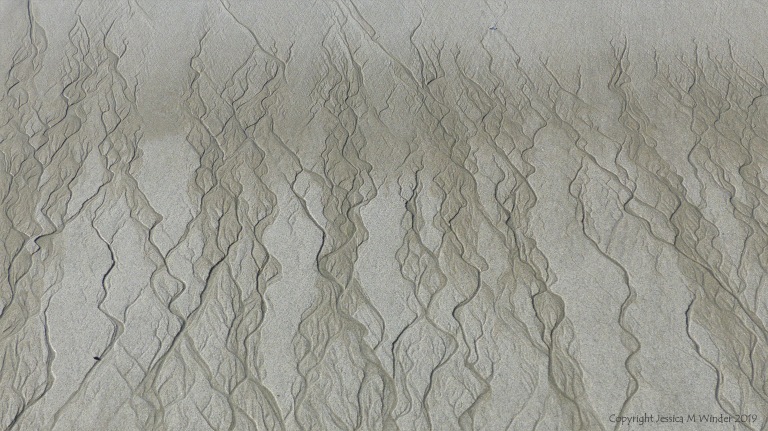 Natural patterns in the sand on a beach as the tide goes out