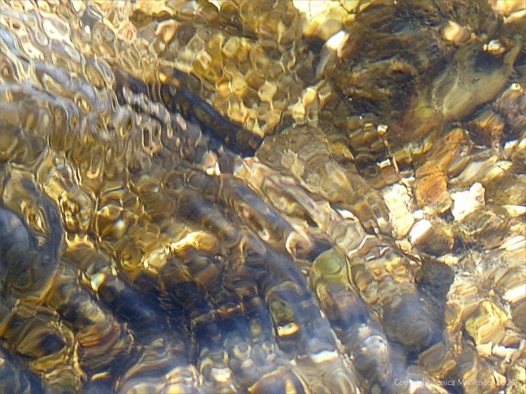 Abstract natural patterns of reflected light on flowing rippled water