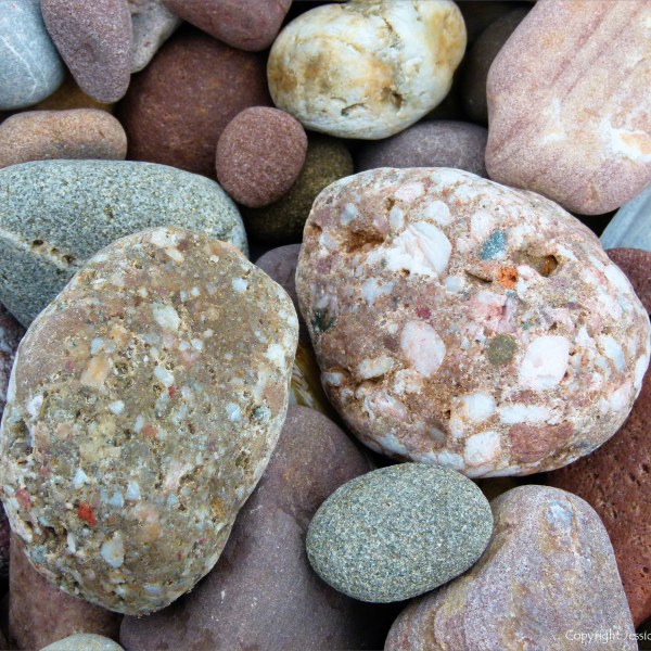 Large pebbles of different rock types on the beach