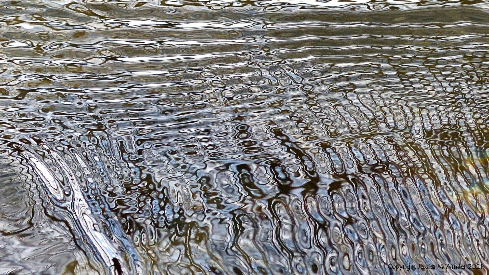 Intricate changing patterns of reflected light on fast flowing water