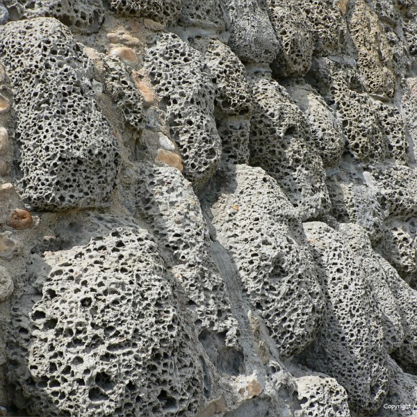 Rocks with holes caused by natural erosion in a sea wall