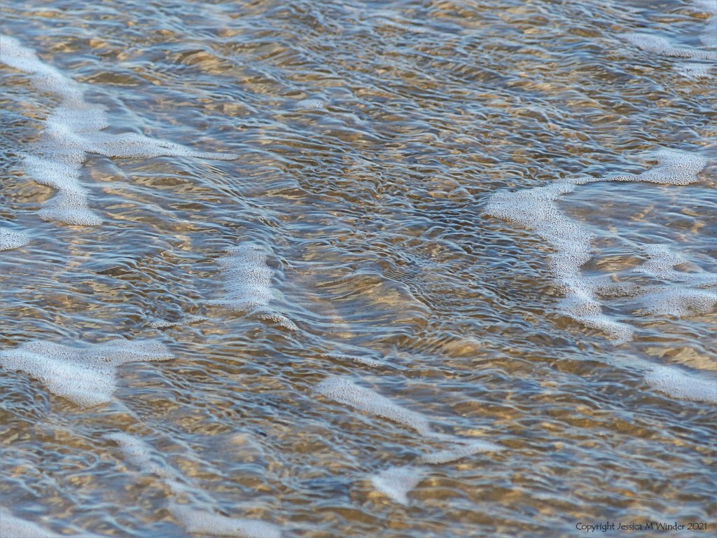 Natural surface texture and pattern of shallow waves breaking on a sandy beach